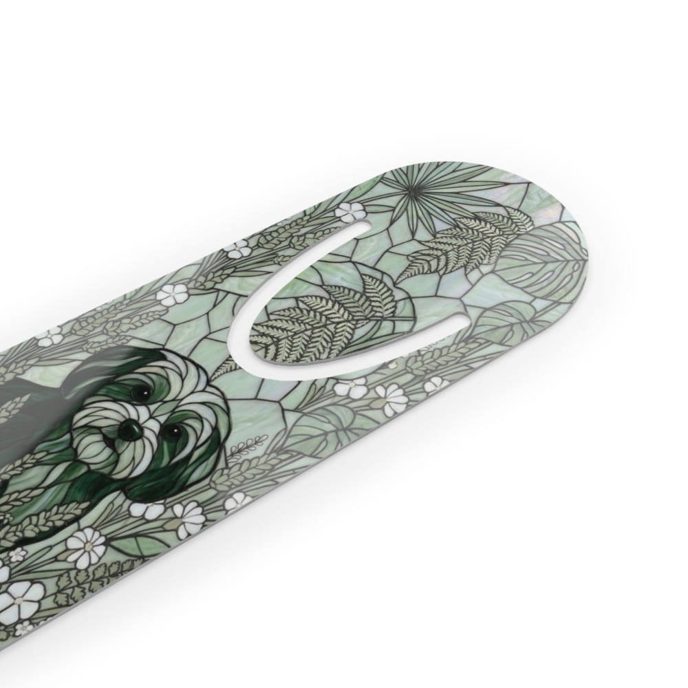 A close-up of a decorative product featuring a green and black dog illustration surrounded by white flowers and leafy botanical patterns on a pale green background.