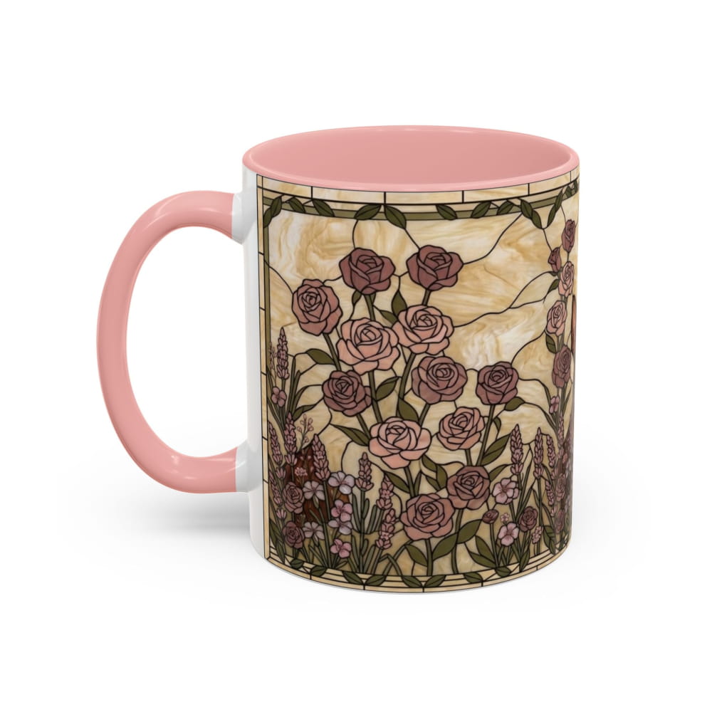 A ceramic mug with a pink handle and interior, featuring a vintage stained-glass style floral design with pink and mauve roses on a cream background.