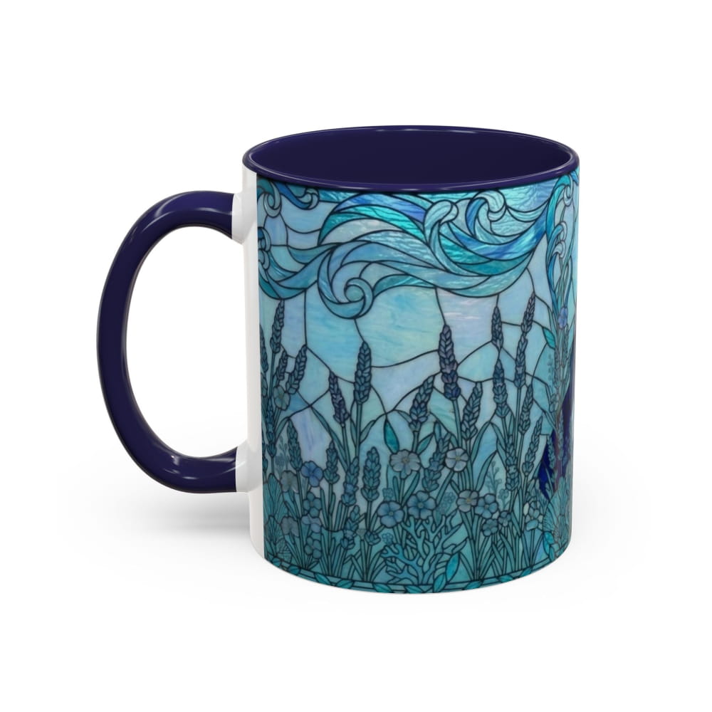 A ceramic mug with a dark navy blue handle and interior, featuring a stained-glass style illustration of blue and teal flowers and waves on the exterior, set against a plain white background.