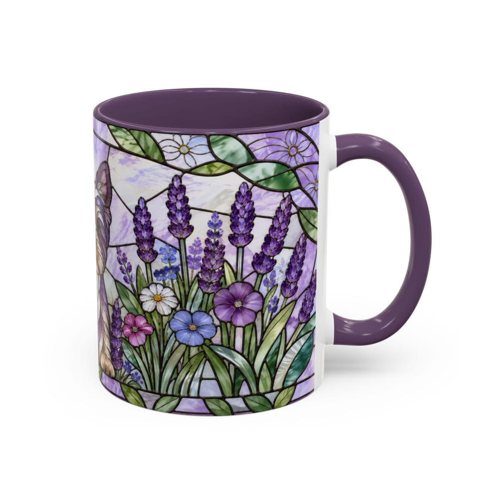 A ceramic mug with a purple handle and interior, featuring a stained-glass style floral design with purple lavender, green leaves, and white and blue flowers on a white background.