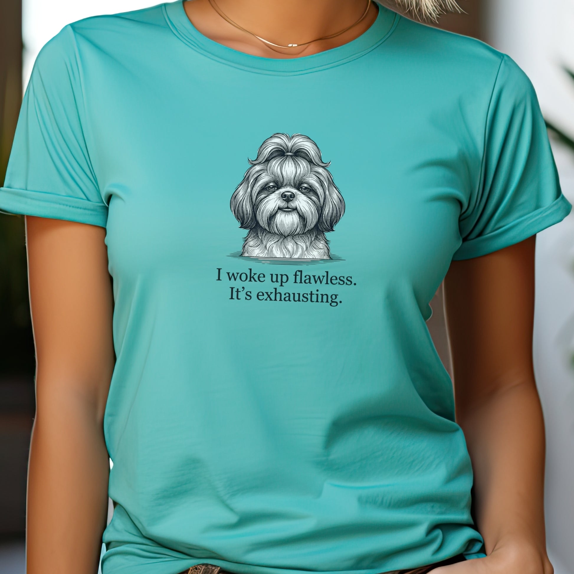 Person wearing a teal t-shirt with a dog illustration and text.
