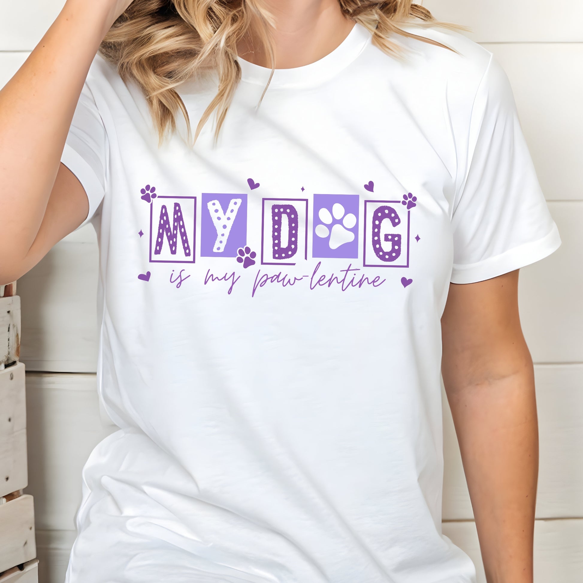 White t-shirt with purple text 'MY DOG is my paw lentine' worn by a person.
