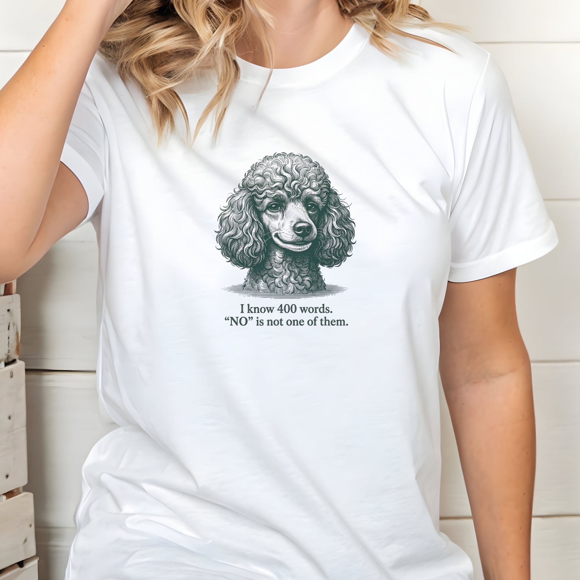 White t-shirt with a poodle graphic and text worn by a person.