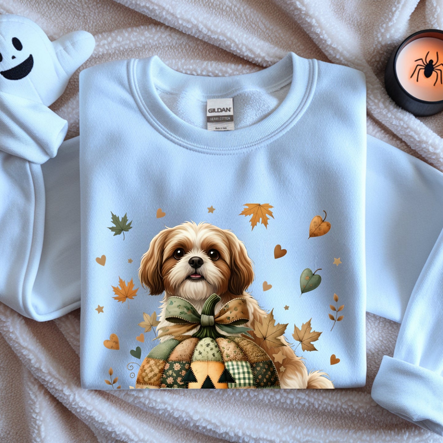 White sweatshirt with a dog graphic and autumn leaves on a textured surface