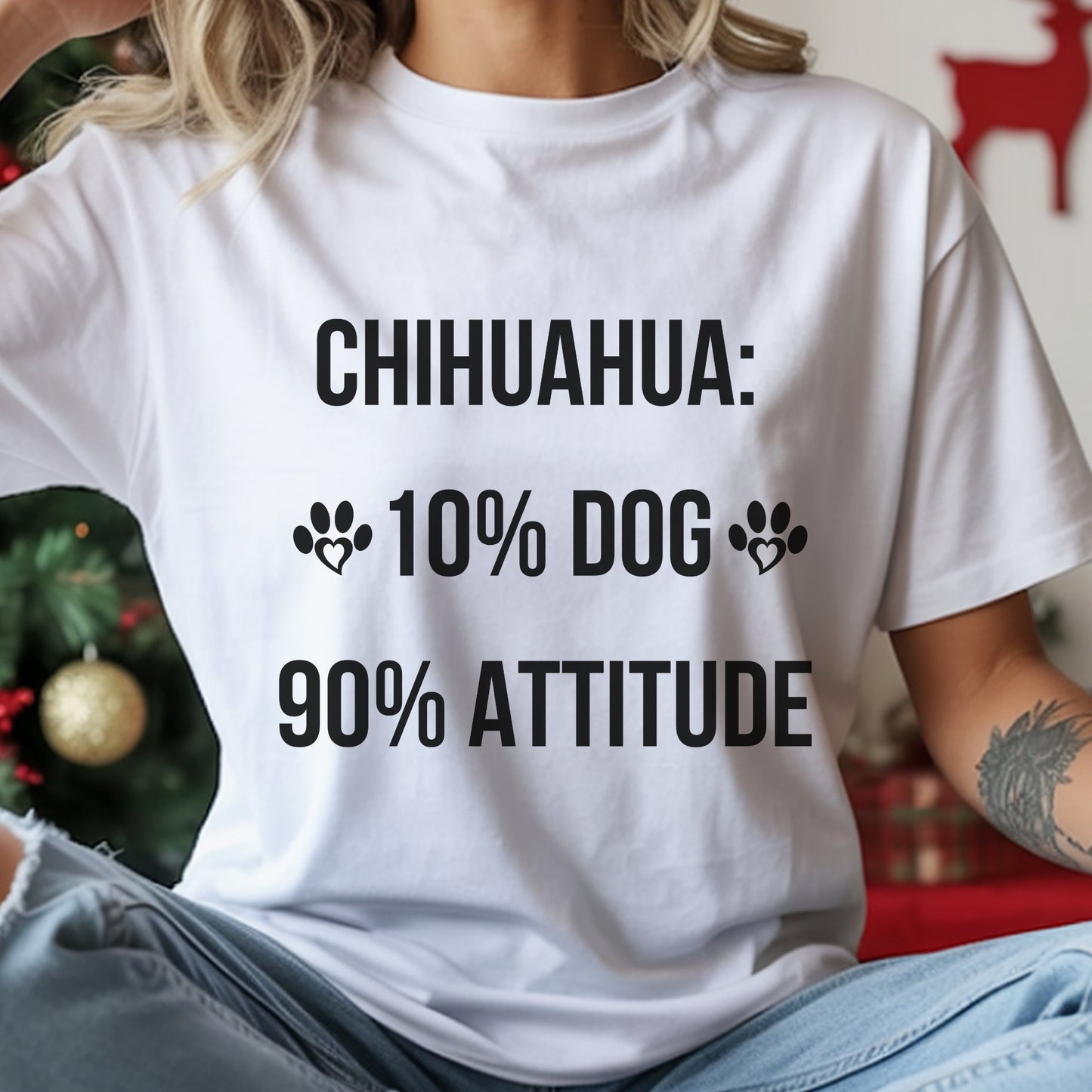 Person wearing a white t-shirt with text about Chihuahuas in front of a Christmas tree.