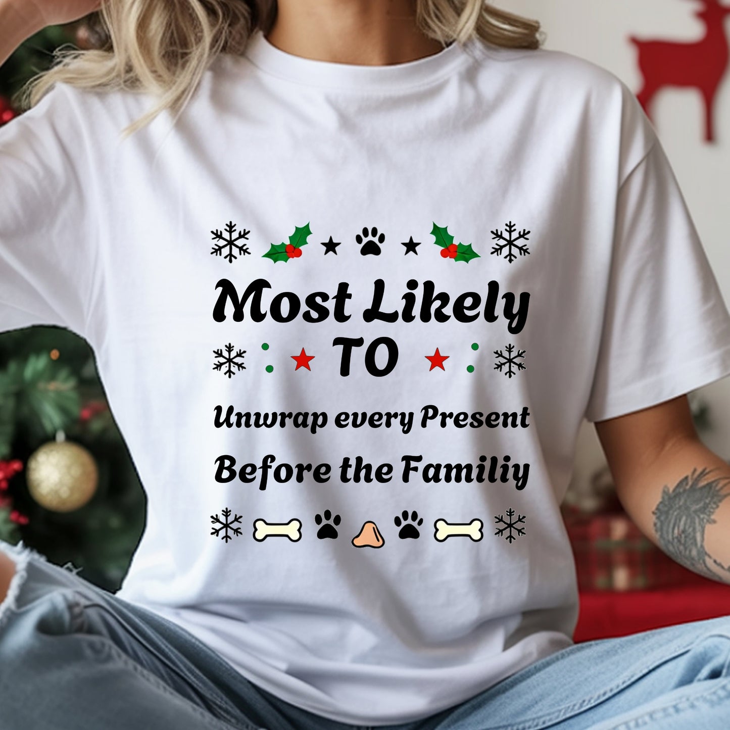 White t-shirt with Christmas-themed text and graphics worn by a person, with a blurred background.