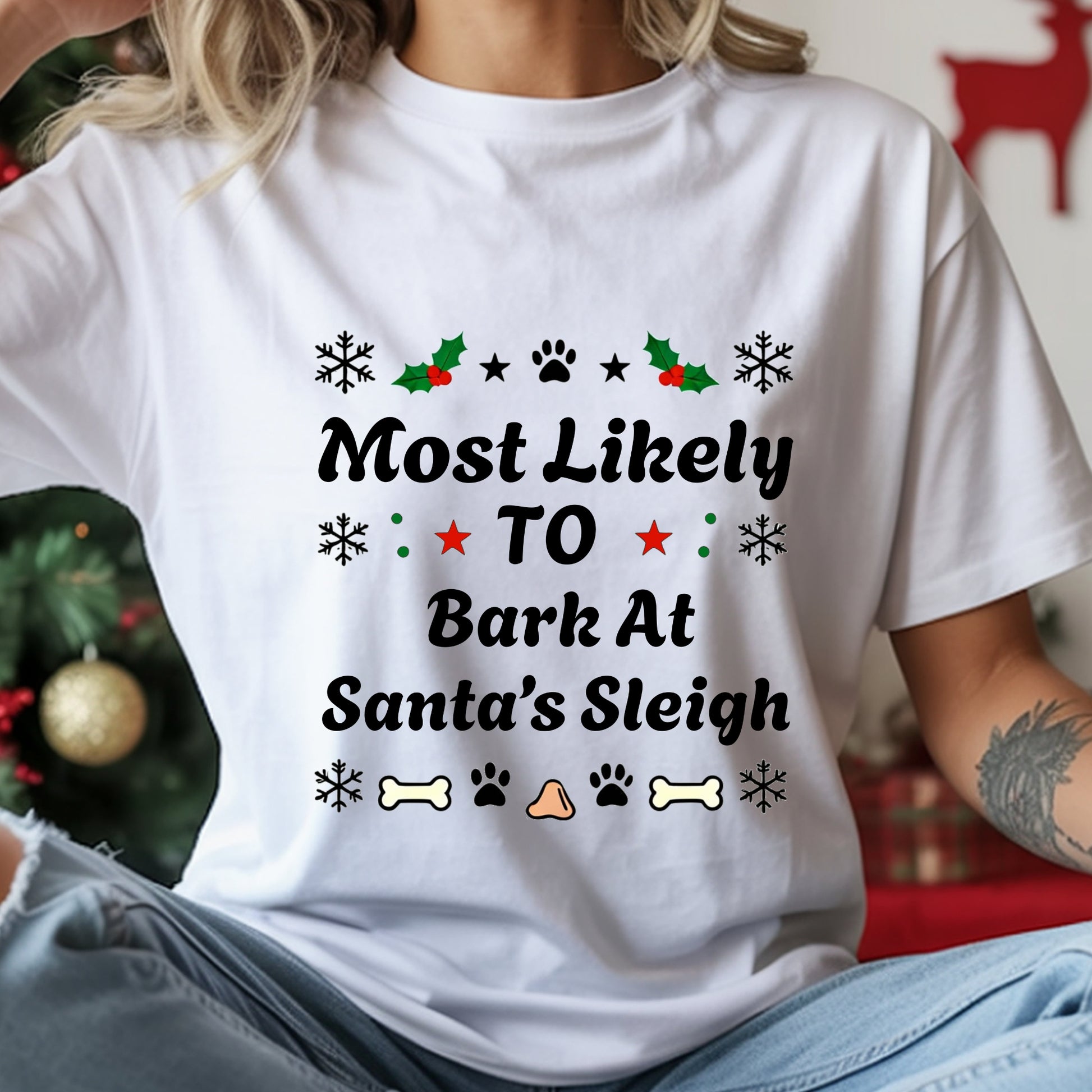 White t-shirt with Christmas-themed text and graphics worn by a person, with a festive background.