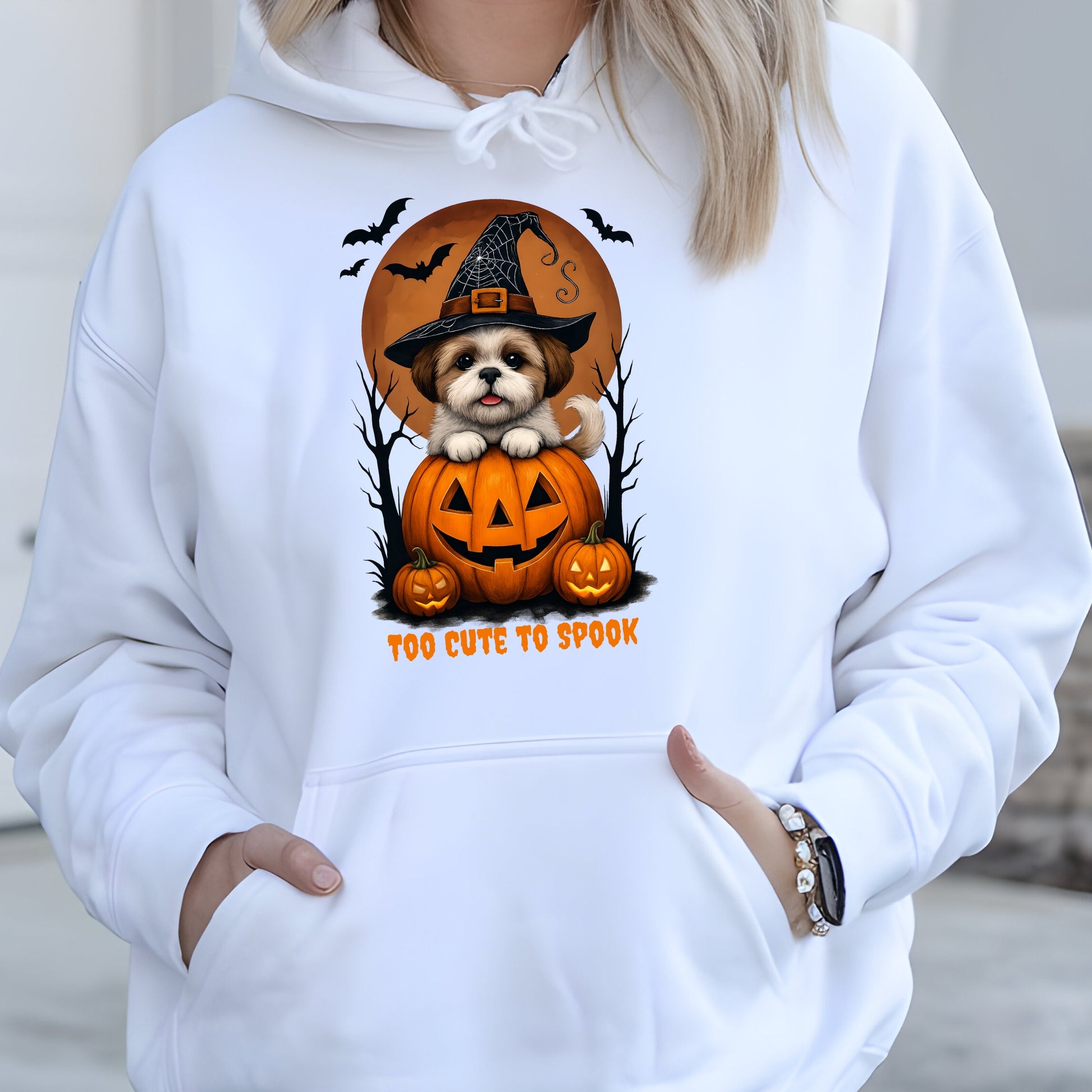 White hoodie with Halloween-themed design featuring a dog in a pumpkin and text 'Too Cute to Spook'.