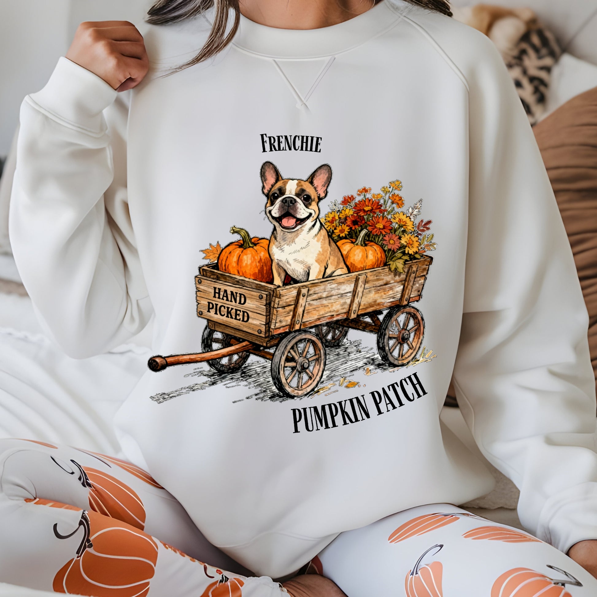 Person wearing a white sweatshirt with a dog and pumpkin patch design.