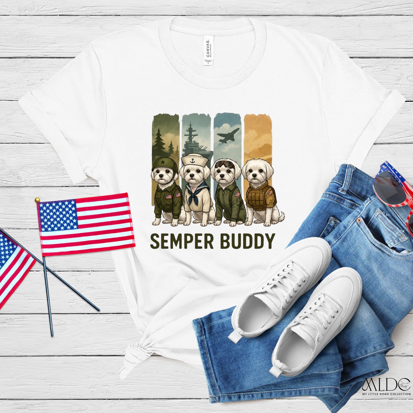 White t-shirt with 'Semper Buddy' graphic, American flags, white sneakers, and blue jeans on a wooden surface.
