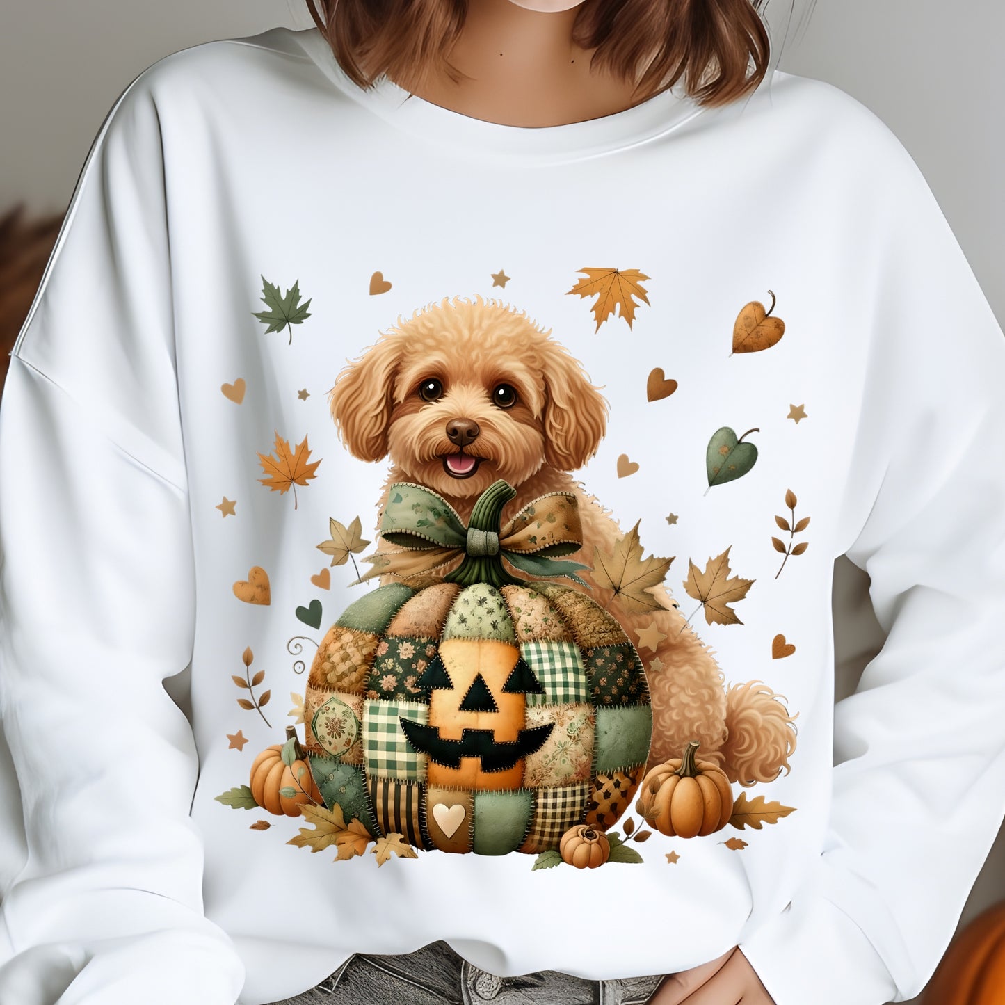 White sweatshirt with a dog in a patchwork pumpkin design and autumn leaves.