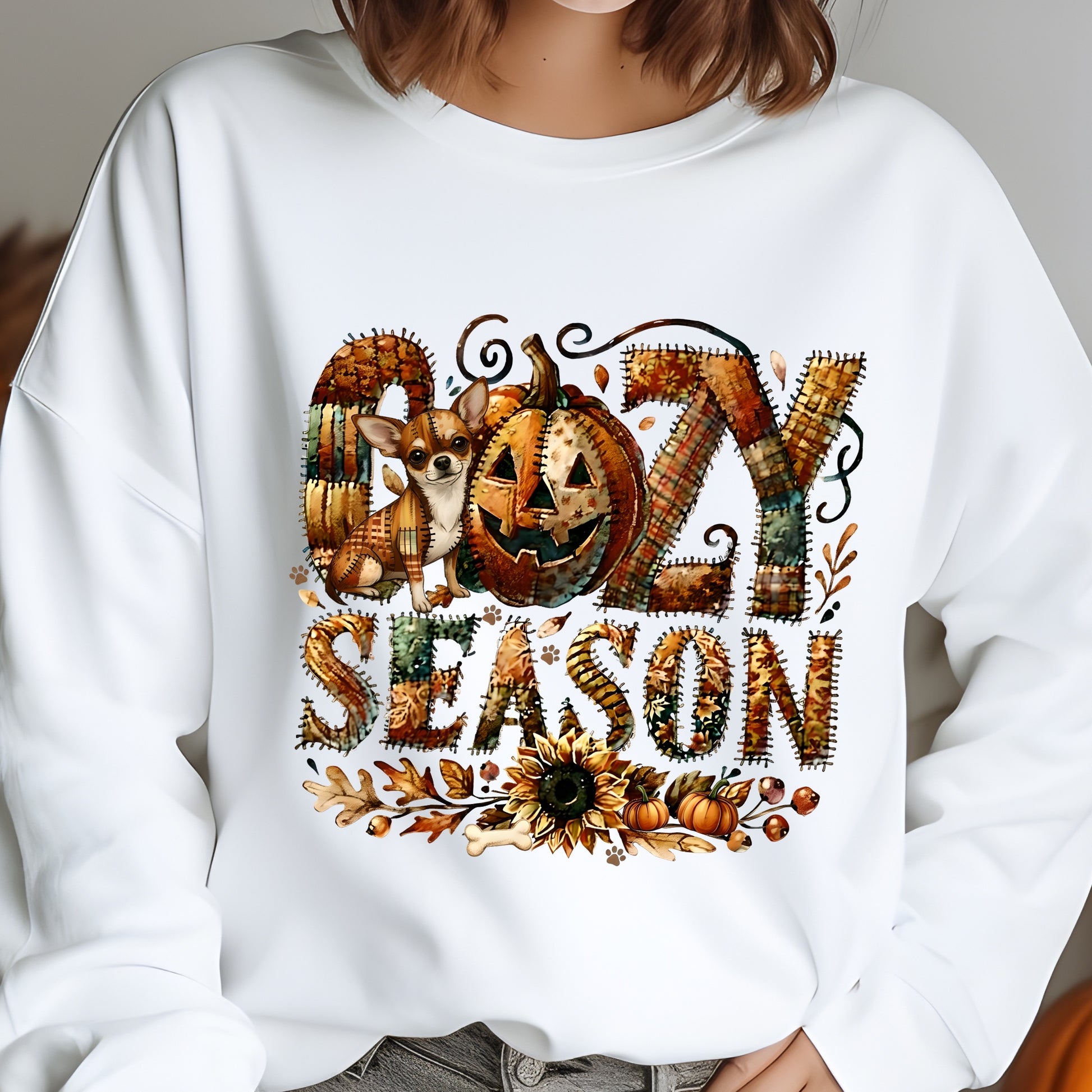 Cozy Season patchwork sweatshirt featuring a hidden Chihuahua in autumn colors, surrounded by pumpkins, leaves, and a sunflower.Cozy patchwork sweatshirt with "Cozy Season" text, autumn colors, pumpkins, sunflower, and a hidden Chihuahua motif.